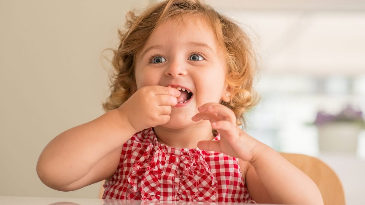 Bimba che mangia con le mani