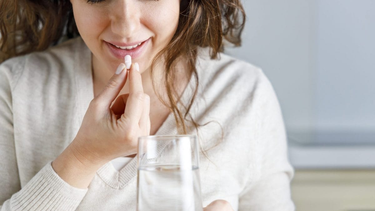 donna che prende una pillola