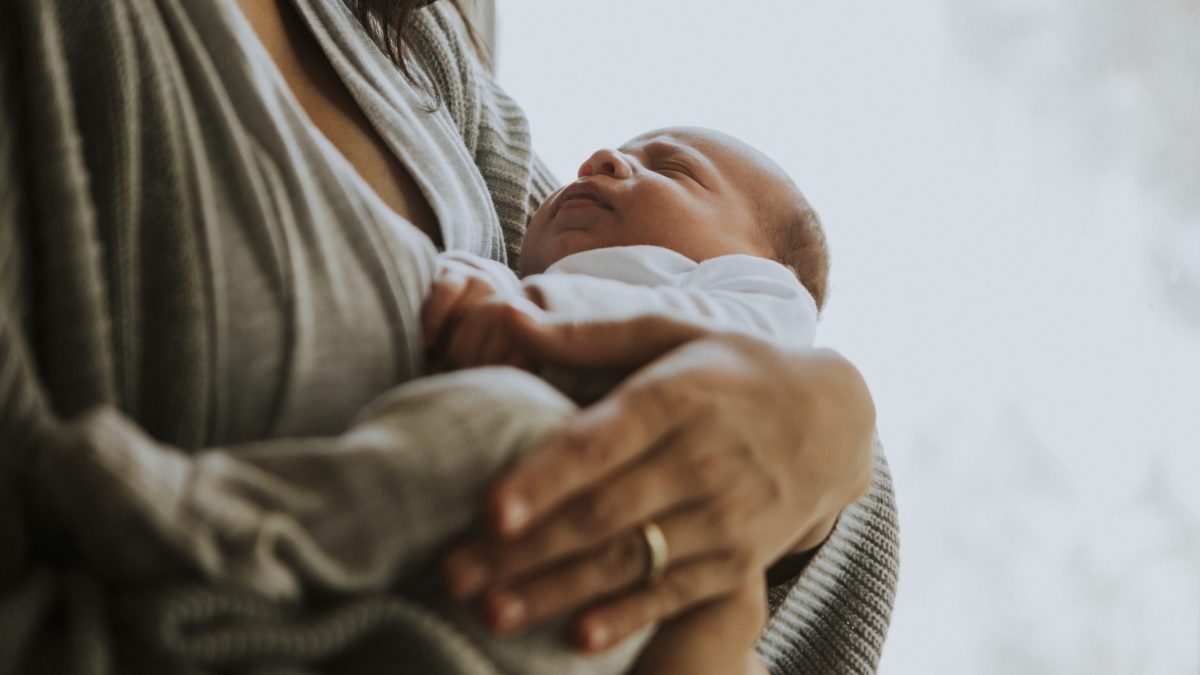 tenere neonato in braccio